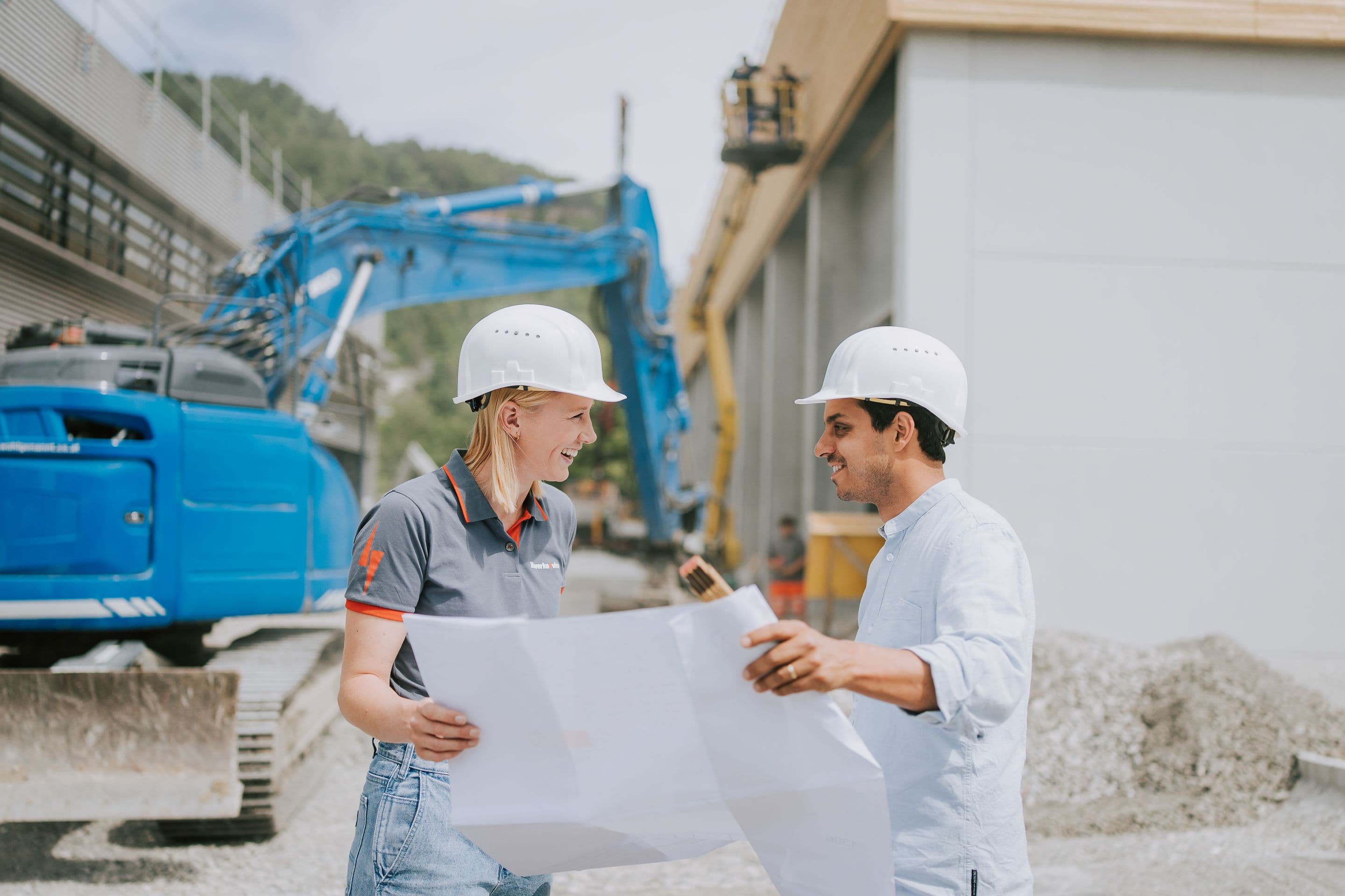 Bauleiter vor Bagger mit Plan